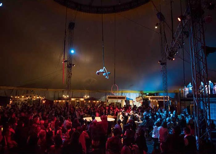 Image of aerialist performing at The Soiled Dove dinner theater under Vau de Vire's Tortona Big Top
